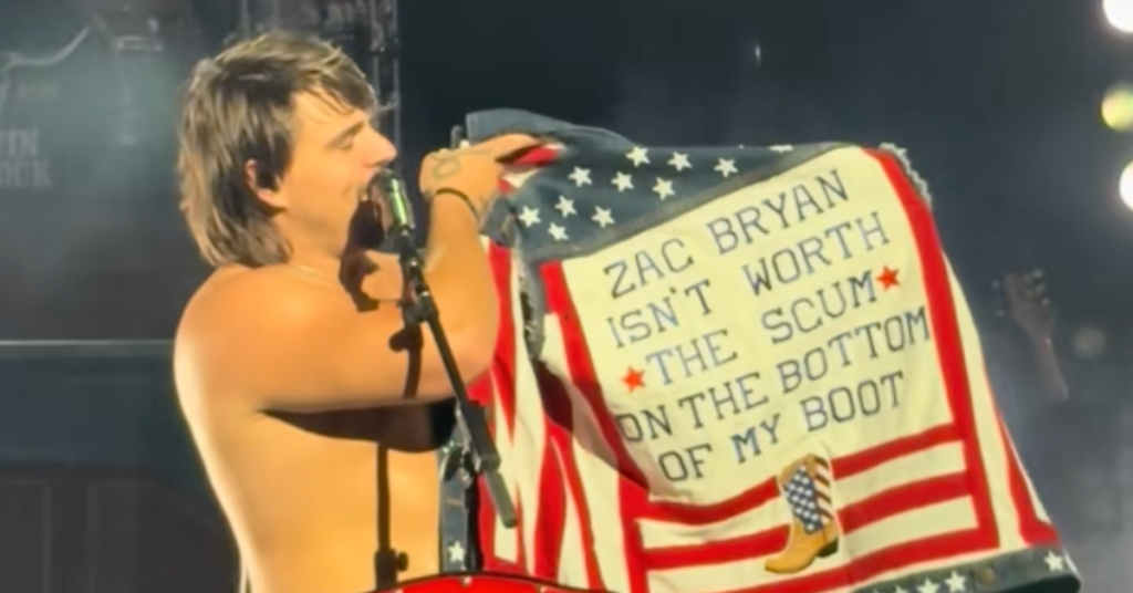 Gavin Adcock Shows Off Fan-Made Jacket That Says “Zach Bryan Isn’t Worth The Scum On The Bottom Of My Boot” At Washington Show: “F*ck That Motherf*cker”